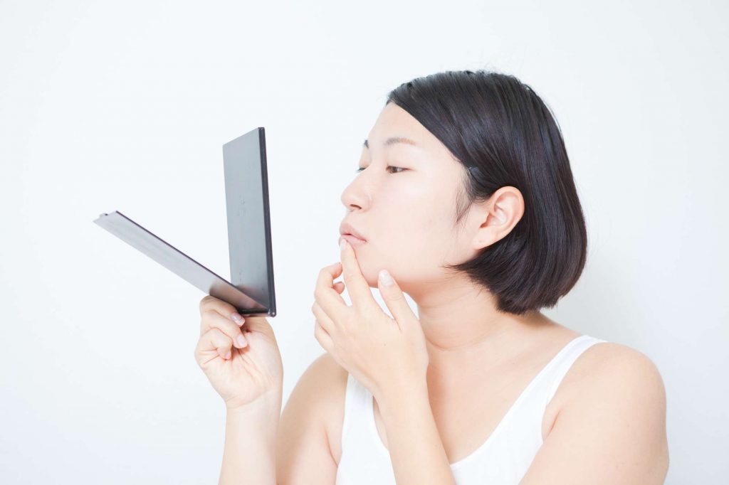 唇の口内炎を気にする女性